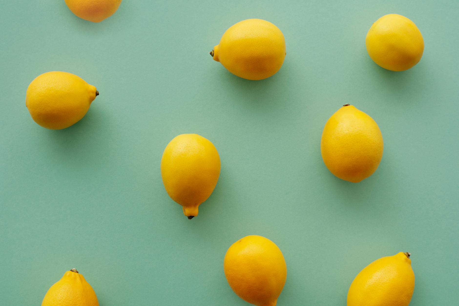 Bright yellow lemons arranged on a pastel green background, symbolizing the natural rhythms of the body's pleasure cycles