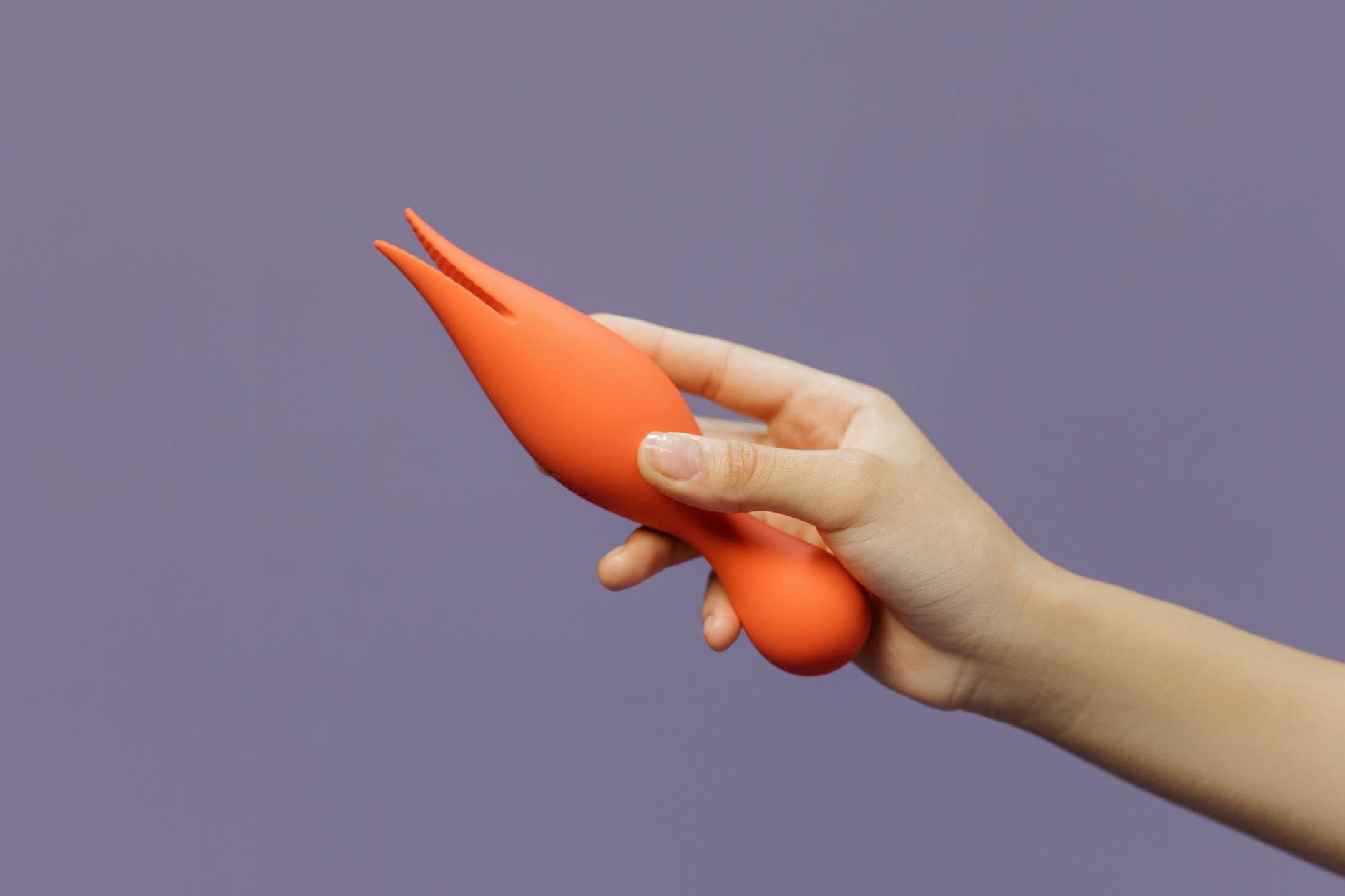 Mão segurando um vibrador de limão moderno contra fundo minimalista e sensual