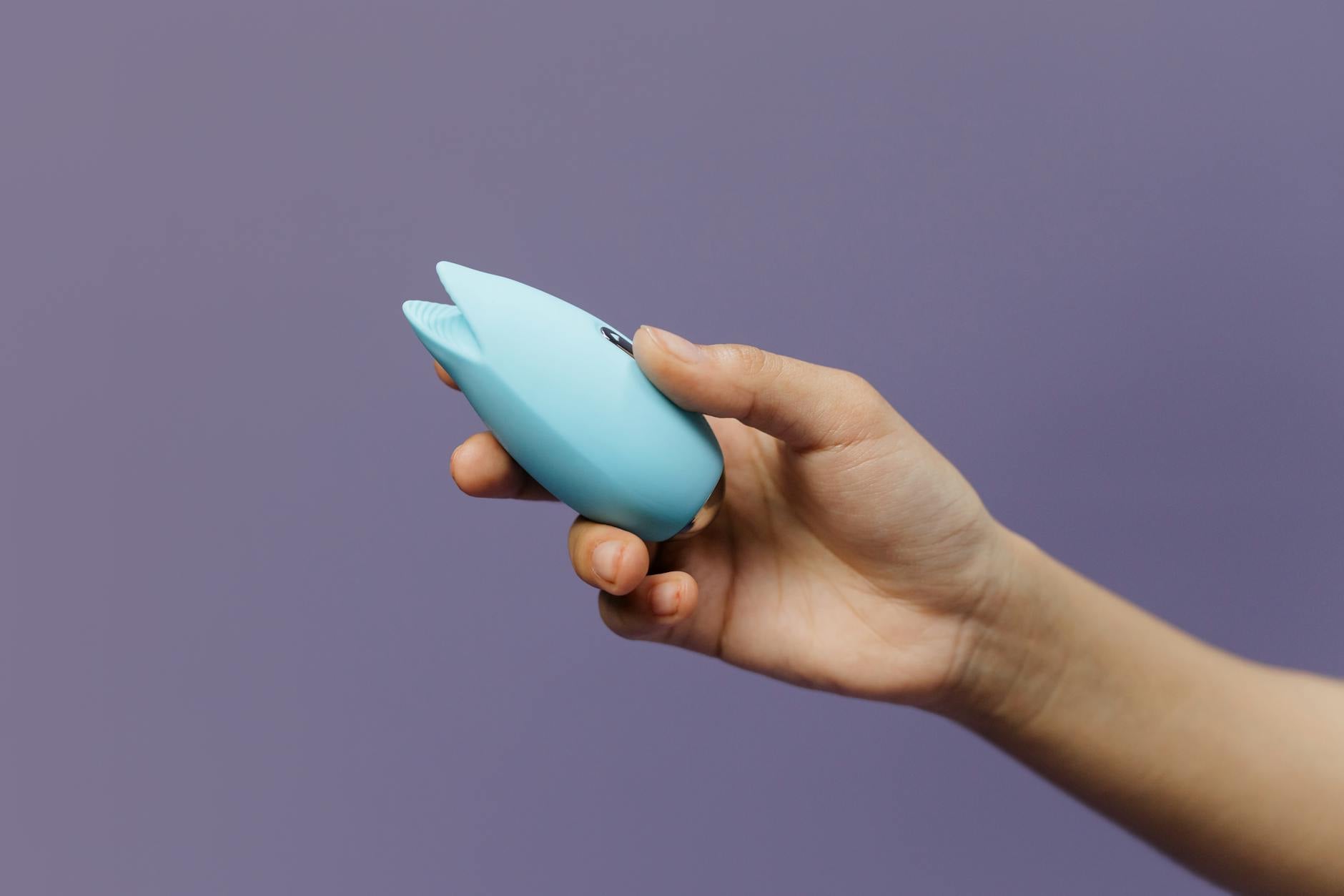 Pink vibrator on purple background with hearts and candles for romantic connection